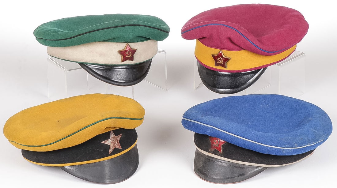 4 EARLY OR EARLY STYLE SOVIET RED ARMY VISOR CAPS: 4 EARLY OR EARLY STYLE SOVIET RED ARMY VISOR CAPS. Each of piped and banded cloth bodies of varying colors designating units and each with enameled red star, one example stamped on interior with maker