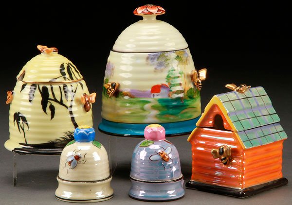 3 NORITAKE ART DECO PORCELAIN HONEY POTS: THREE HAND PAINTED NORITAKE ART DECO PORCELAIN HONEY POTS, EARLY 20TH CENTURY. Two in the form of beehives and one in a gabled roof house. Together with two beehive form salt dip/pepper shakers. Marke