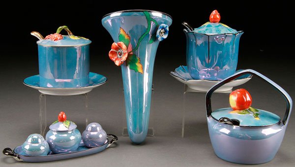8 PIECES NORITAKE ART DECO PORCELAIN: AN EIGHT PIECE HAND PAINTED NORITAKE ART DECO PORCELAIN GROUP, EARLY 20TH CENTURY. All with applied figural flowers and fruit, on blue luster ground. Comprising two covered jars with ladles and underp