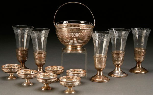 12 PIECES STERLING AND ETCHED GLASS TABLEWARES: A 12 PIECE STERLING AND ETCHED GLASS TABLEWARES GROUP, EARLY 20TH CENTURY. Comprising five etched crystal parfait glasses in Webster sterling holders, an etched glass bowl in a reticulated handled ste