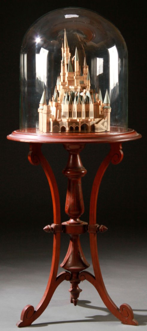 VICTORIAN DIECUT ARCHITECTURAL MODEL & STAND: AN INTERESTING VICTORIAN DIE CUT PAPER LITHO ARCHITECTURAL MODEL AND AESTHETIC WALNUT STAND. In the manner of Neuschwanstein Castle, contained under a glass dome, raised on a walnut three legged pedes