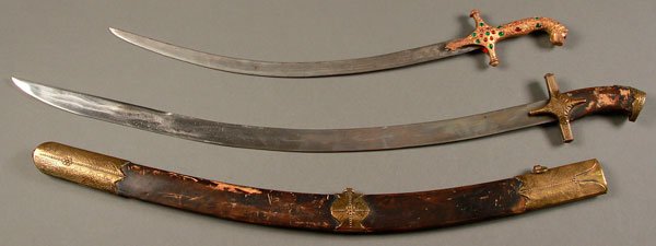 PAIR OF INDO-PERSIAN SWORDS, 19TH CENTURY: A PAIR OF INDO-PERSIAN SWORDS, 19TH CENTURY. Comprising a shamshir with heavy gilt-bronze lion head pommel handle set with cabochon paste stones, length 25.6 inches (66 cm). Together with a curved sw