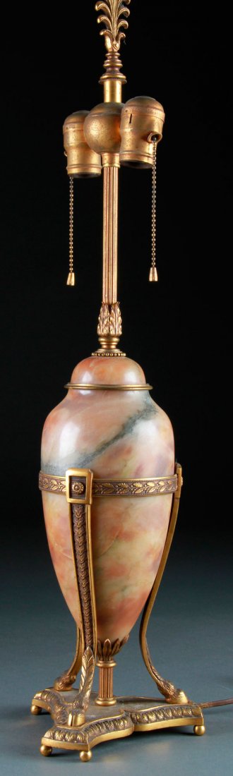 FRENCH GILT BRONZE AND ALABASTER CASSOLETTE/LAMP: A FRENCH GILT BRONZE AND ALABASTER CASSOLETTE/TABLE LAMP, EARLY 20TH CENTURY. The urn form raised on tripod antelope legs, surmounting a shaped bronze plinth. Height 27 inches (69 cm).