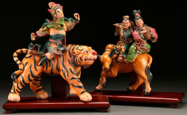 CHINESE GLAZED POTTERY TILE FIGURES: A PAIR OF CHINESE GLAZED POTTERY ARCHITECTURAL TILE FIGURES. Finely modeled as a figure on tiger and two musicians on water buffalo, each raised on later wood stands. Height 14.75 inches (37.5 cm) sta