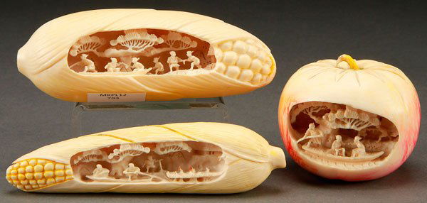 THREE JAPANESE CARVED IVORY OKIMONOS: THREE JAPANESE CARVED IVORY OKIMONOS, 20TH CENTURY. Comprising two figural ears of corn, each with finely craved miniature scenic dioramas. Together with a carved figural tomato with similarly carved