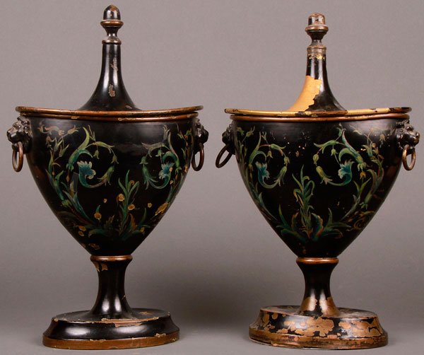 PAIR OF REGENCY TOLE PAINTED CHESTNUT URNS: A PAIR OF REGENCY TOLE PAINTED CHESTNUT URNS. With lions head masks and ringed handles. Painted with polychrome foliates on a black Jappaned reserve below spiked finial lids. Losses to black ground. H