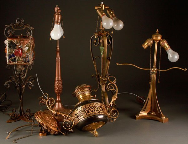 FIVE VINTAGE LAMPS, LATE 19TH/EARLY 20TH CENTURY: FIVE VINTAGE LAMPS, LATE 19TH/EARLY 20TH CENTURY. Comprising a wrought iron table lamp with multi-colored rock glass shade, an ormolu base, a scrolled iron base, an Art Nouveau bronze base, and a Vict