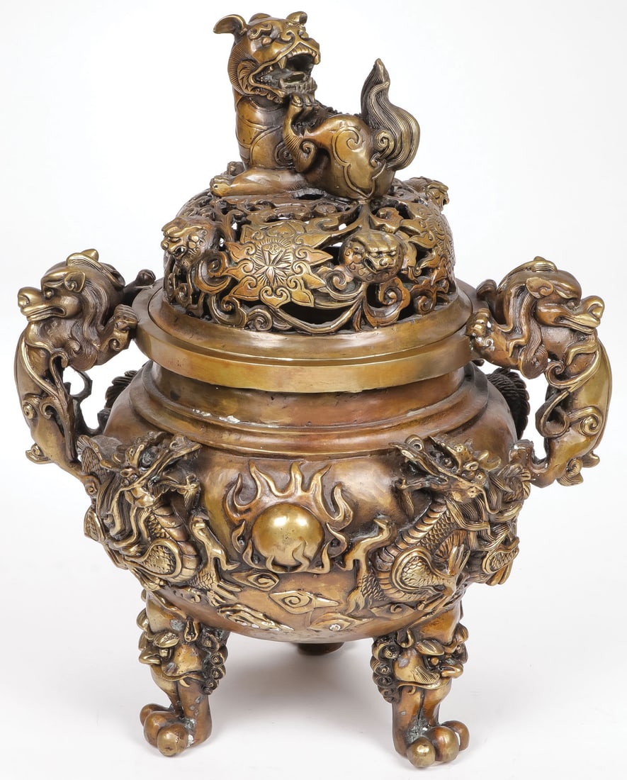 IMPRESSIVE CHINESE BRONZE DRAGON CENSER: IMPRESSIVE CHINESE BRONZE DRAGON CENSER. Resting on three paw feet, the sides with dragons chasing the flaming pearl, the handles modeled as foo dogs, and the domed pierced lid with foo finial. The un
