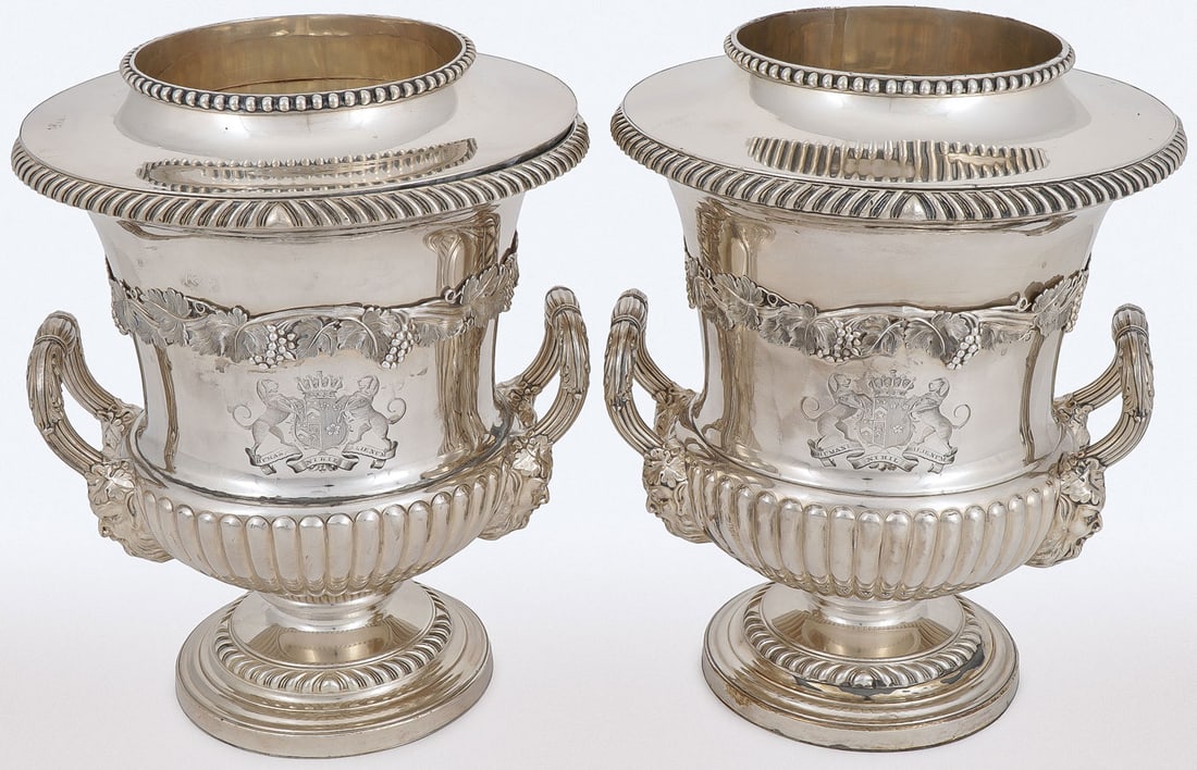 A PAIR OF OLD SHEFFIELD PLATE WINE COOLERS: A PAIR OF OLD SHEFFIELD PLATE WINE COOLERS. Of campagna urn form, with removable liner with gadrooned edge, above an applied band of grape vines, at center an engraved coat of arms with banner inscrib