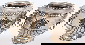 PAIR OF GEORGIAN SILVER-PLATED WINE COOLERS: PAIR OF GEORGIAN SILVER-PLATED WINE COOLERS. Comprising a pair of English silver-plated wine coolers, of urn form, engraved with coat of arms and motto "Juncti Valemus," with lion's head ring handles,