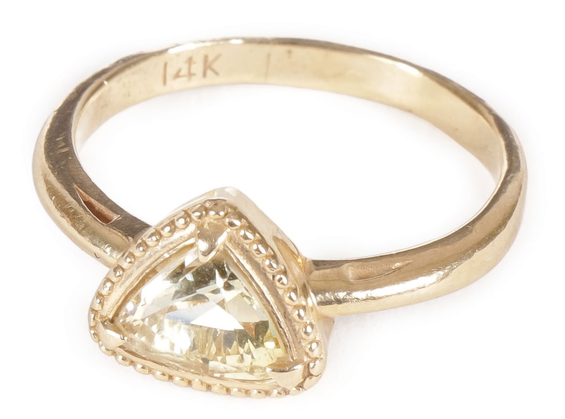 LADIES GOLD AND YELLOW SAPPHIRE RING: LADIES GOLD AND YELLOW SAPPHIRE RING. Comprising a 14kt gold ring mounted with an approximate 1.25ct triangular cut yellow sapphire ring. Approximate size 6 1/2. SHIPPING NOTICE:If you are not using