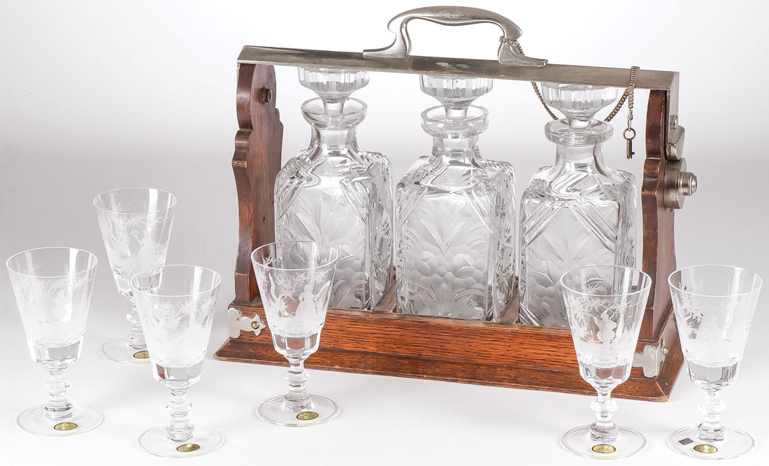 A STURDY OAK TANTALUS & GOBLETS, 19TH C: A STURDY OAK TANTALUS & GOBLETS, 19TH C. Comprising a sturdy oak and nickel plated tantalus, English 19th century. Containing three heavily cut and etched lead crystal decanters with stoppers and the