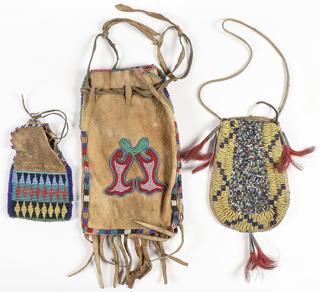 3 PLAINS BEADED BAGS, C. 1880-1915: 3 PLAINS BEADED BAGS, C. 1880-1915. Comprising a good hand-tanned ovoid bag with yellow greasy beaded border surrounding a profusion of varicolored beads, sinew lazy-stitched with red-dyed horsehair t