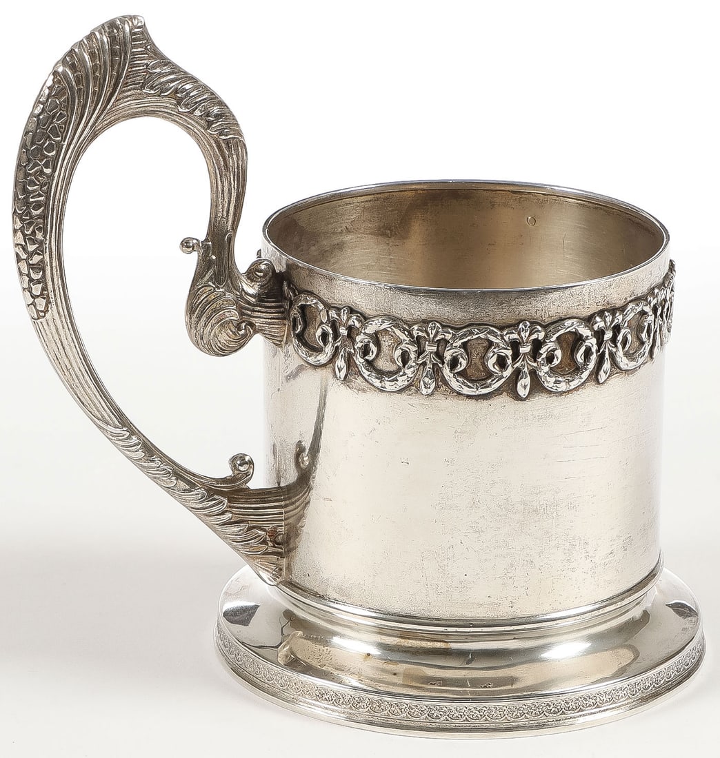 RUSSIAN SILVER TEA GLASS HOLDER, 13TH ARTEL: RUSSIAN SILVER TEA GLASS HOLDER, 13TH ARTEL. With Art Nouveau-style sweeping handle, the rim banded with interlocking swags and laurel wreaths. Hallmarked Moscow, 1908-1917, and maker's mark 13A (13th