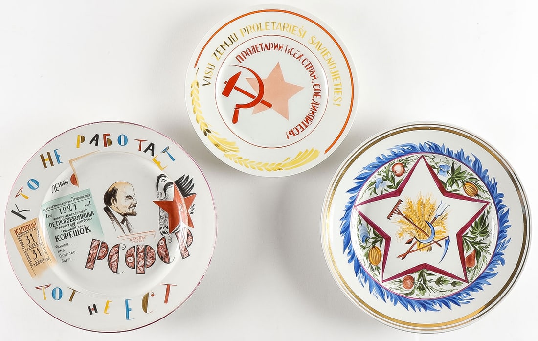 TWO SOVIET STYLE PROPAGANDA PLATES: TWO SOVIET STYLE PROPAGANDA PLATES. Comprising two hand-painted propaganda plates, the underside of each bearing a hammer and sickle mark, bearing the date 1921, and further inscribed with the name o
