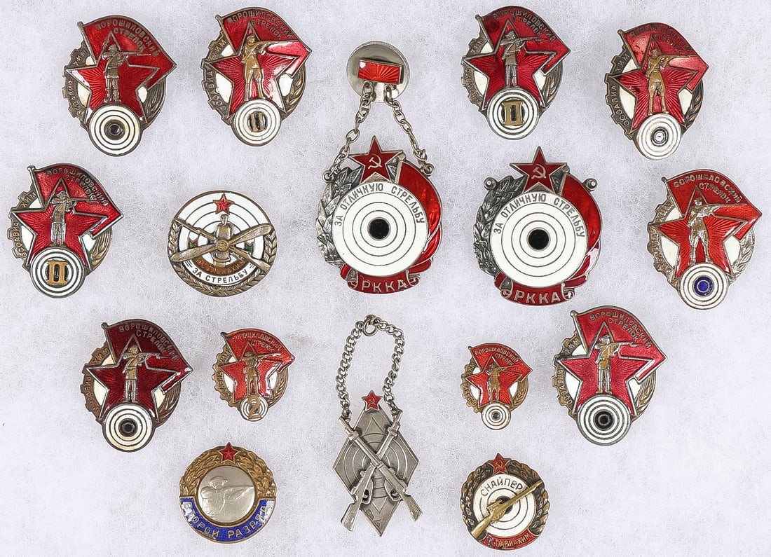 16 GOOD EARLY SOVIET SHOOTING BADGES: 16 GOOD EARLY SOVIET SHOOTING BADGES. Comprising a good group of various types of early Soviet shooting and marksmanship badges. The top row displays four Voroshilov marksmanship badges, including two