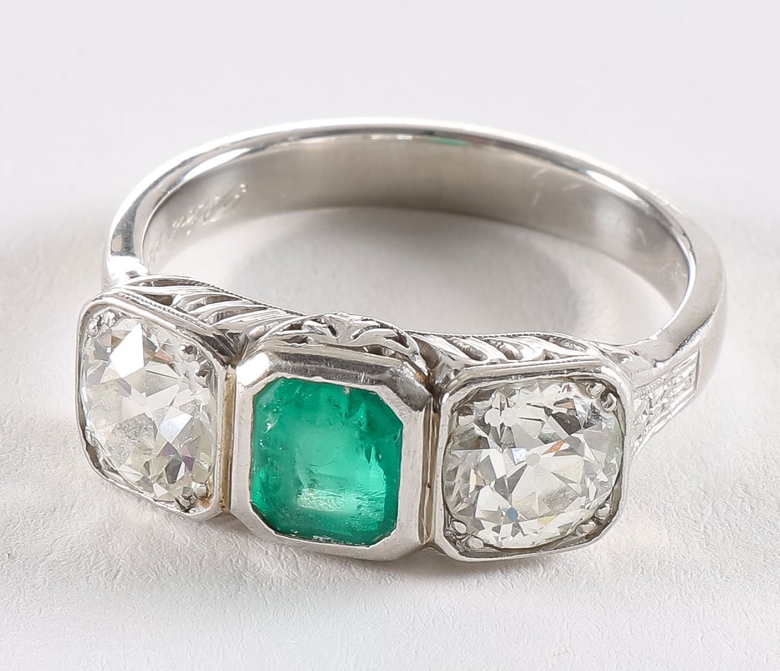 LADIES PLATINUM DIAMOND & EMERALD RING: LADIES PLATINUM DIAMOND & EMERALD RING. Comprising a lovely ladies platinum diamond and emerald ladies ring, centered with an emerald cut rich green emerald approximately 1 carat, flanked by two appro