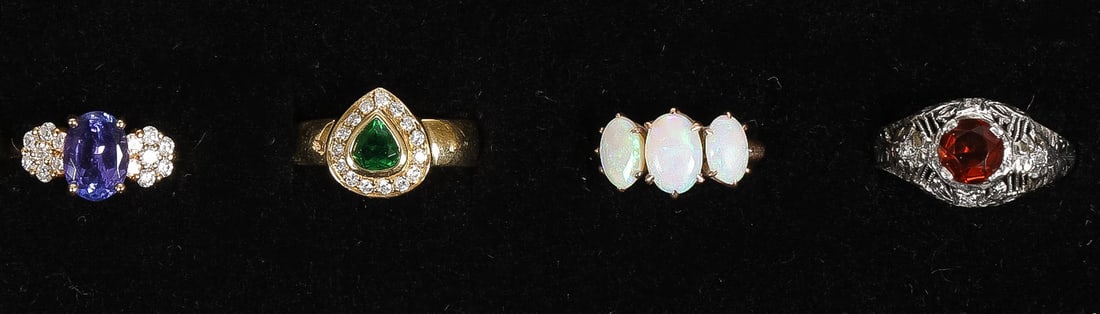FOUR GOLD & PLATINUM JEWELED LADIES RINGS: FOUR GOLD & PLATINUM JEWELED LADIES RINGS. Comprising a ladies' platinum filigree garnet ring with two cut diamonds (4.25 dwt), a 14K gold ring set with three opals (1.20 dwt), an 18K halo diamond rin