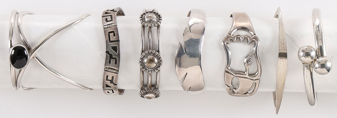 7 MEXICAN SILVER BANGLE BRACELET: 7 MEXICAN SILVER BANGLE BRACELET. All but one marked .925 or sterling, but tests silver. Various shapes and sizes as shown and one modern example with polished black cabochon, and each with various ma