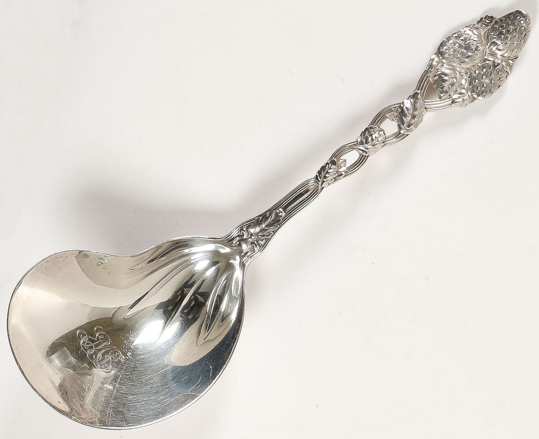 HEAVY STERLING TIFFANY SERVING SPOON: HEAVY STERLING TIFFANY SERVING SPOON. Comprising a heavy and ornate Tiffany sterling strawberry serving spoon. The twist handle decorated with strawberries and the bowl monogrammed. Verso marked TIFFA