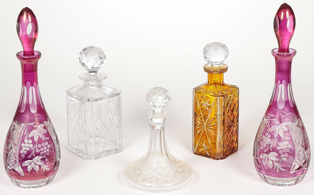 5 VINTAGE CUT GLASS DECANTERS: 5 VINTAGE CUT GLASS DECANTERS. Comprising five individual vintage cut glass decanters, including a pair of ruby-flashed and cut-back bottle-form decanters, an amber cut glass decanter, and two others,