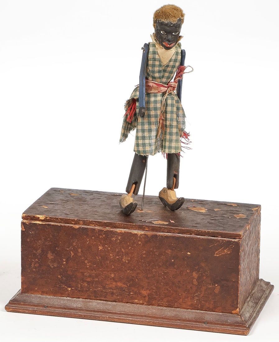 BLACK AMERICANA DANCING AUTOMATON, C. 1880: BLACK AMERICANA DANCING AUTOMATON, C. 1880. Comprising an early clockwork wind-up automaton dancing minstrel male figure of carved and painted wood with articulated joints and original clothing and ha