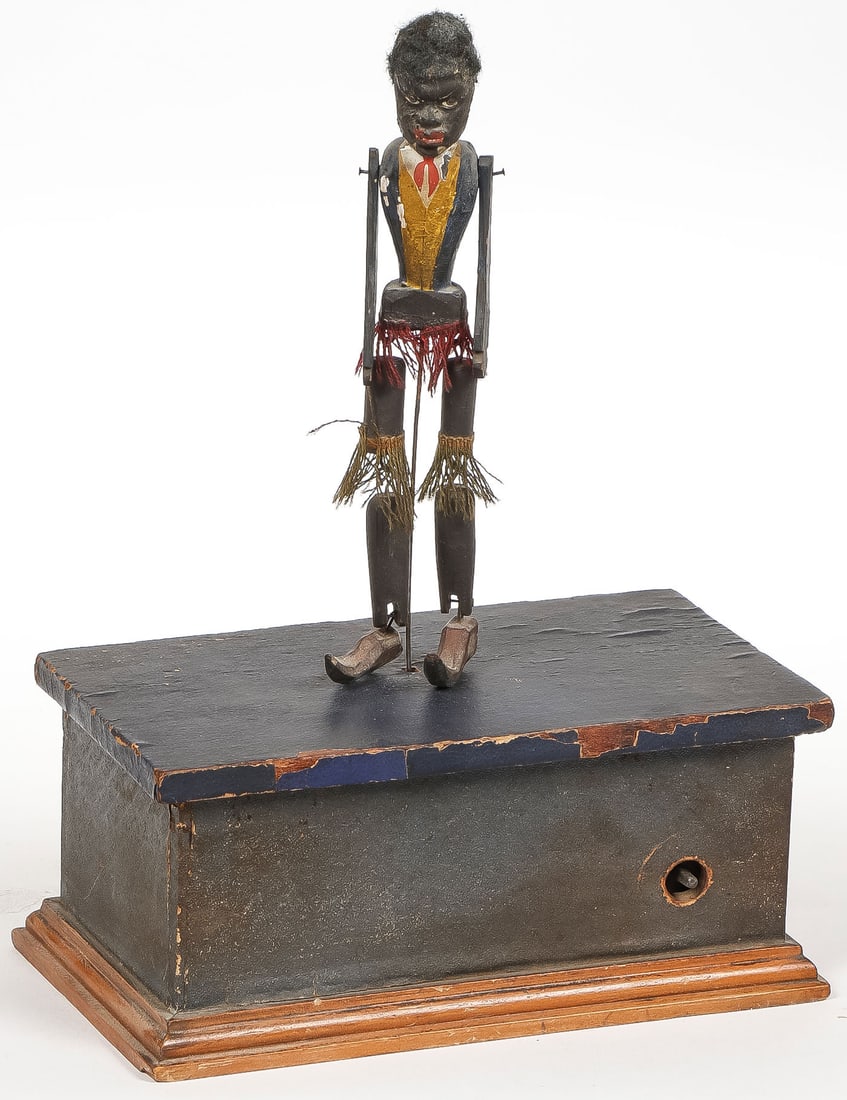 BLACK AMERICANA DANCING AUTOMATON, C. 1880: BLACK AMERICANA DANCING AUTOMATON, C. 1880. Comprising an early clockwork wind-up automaton dancing minstrel male figure of carved and painted wood with articulated joints and original clothing and ha