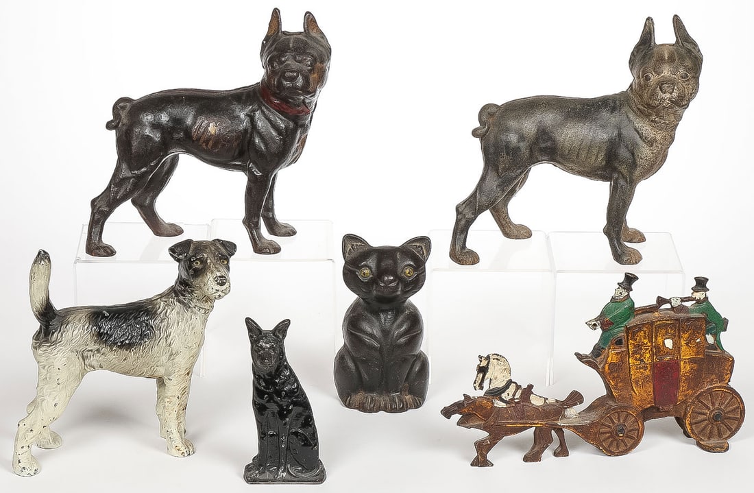 6 VINTAGE CAST IRON DOORSTOPS: 6 VINTAGE CAST IRON DOORSTOPS. Comprising four dogs, a black cat, and a coach. Greatest height 10 inches, greatest length 12.5 inches.SHIPPING NOTICE:If you are not using the Live Auctioneers Live S