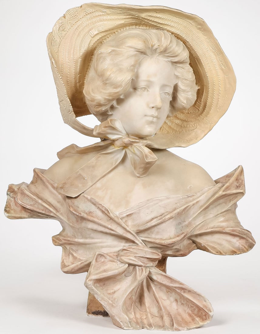 GILDED AGE CARVED BUST OF A BEAUTY, C. 1890: GILDED AGE CARVED BUST OF A BEAUTY, C. 1890. Comprising a large and impressive carved marble or alabaster bust of a young beauty with a ribbon-tied straw hat. Apparently unsigned. Height 26 inches (66
