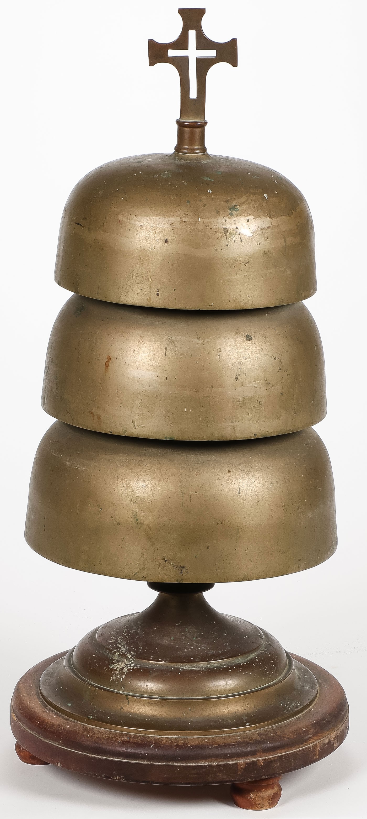 VINTAGE CAST BRONZE ALTAR BELL: VINTAGE CAST BRONZE ALTAR BELL. Comprising a three-domed brass altar bell, resting on a raised, footed wood base, and with cross finial. Height 27 inches.SHIPPING NOTICE:If you are not using the Liv