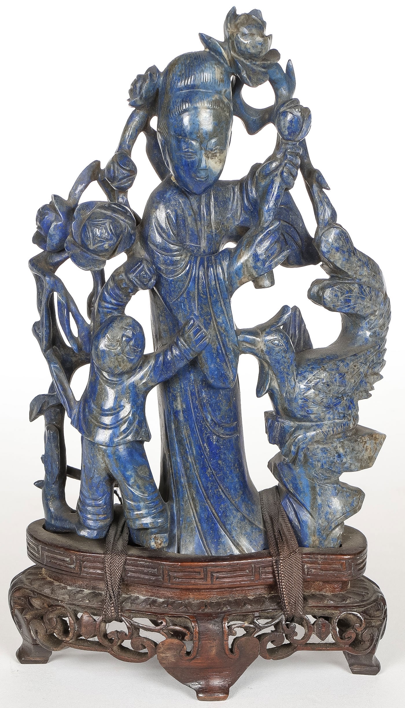 GOOD CHINESE CARVED LAPIS GUANYIN, QING: GOOD CHINESE CARVED LAPIS GUANYIN, QING. Comprising a finely carved figure of Guanyin amidst blossoming flowers, with young child and exotic bird. Finely carved in full round, of good proportions with