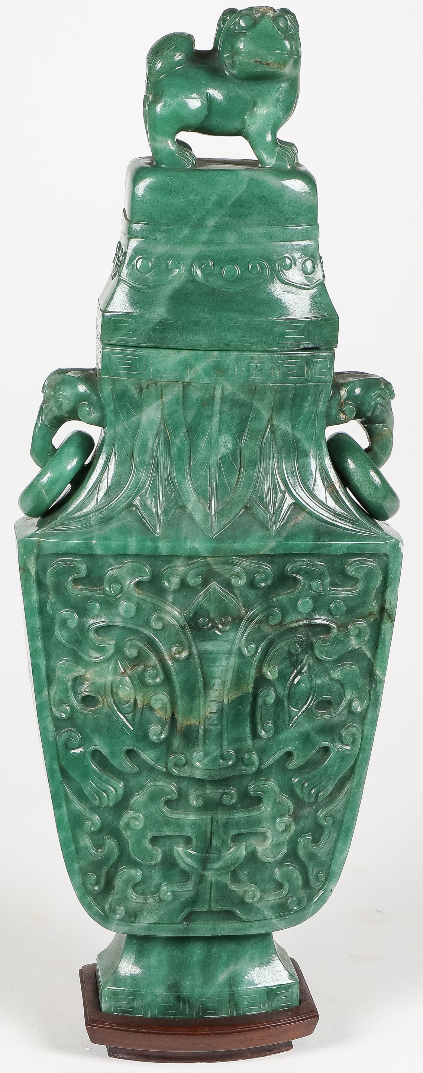 LARGE CHINESE CARVED SPINACH JADE COVERED VASE: LARGE CHINESE CARVED SPINACH JADE COVERED VASE. Comprising a large and impressive archaistic-style relief-carved spinach jade vase with ring handles and a fitted cover with foo-finial. Some old minor