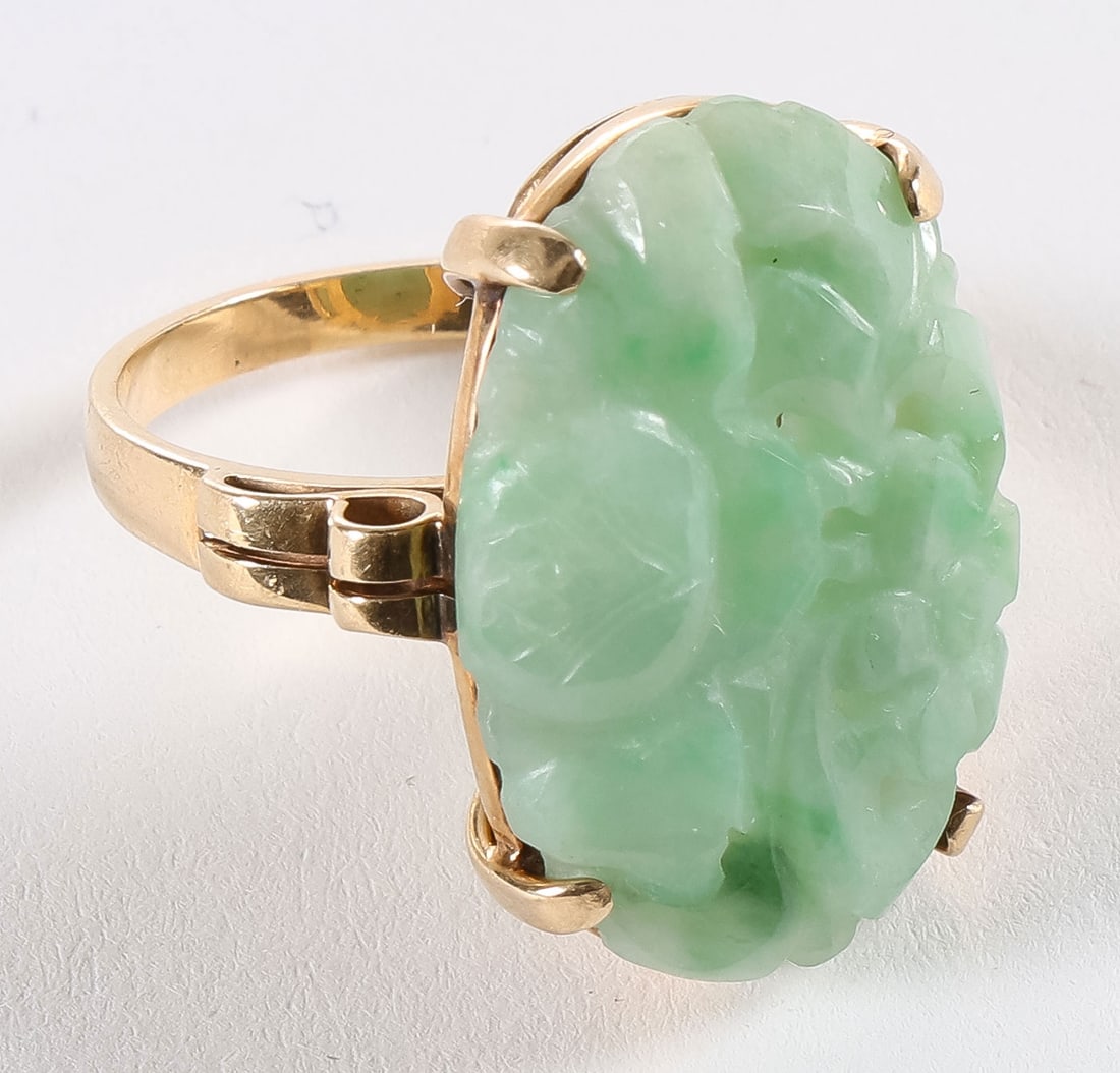 14K GOLD & JADE LADIES RING: 14K GOLD & JADE LADIES RING. Comprising a 14-karat yellow gold ring set with a Chinese oval pierced carved jade medallion carved in high relief with blossoming flowers. Total weight 6 grams.SHIPPING N