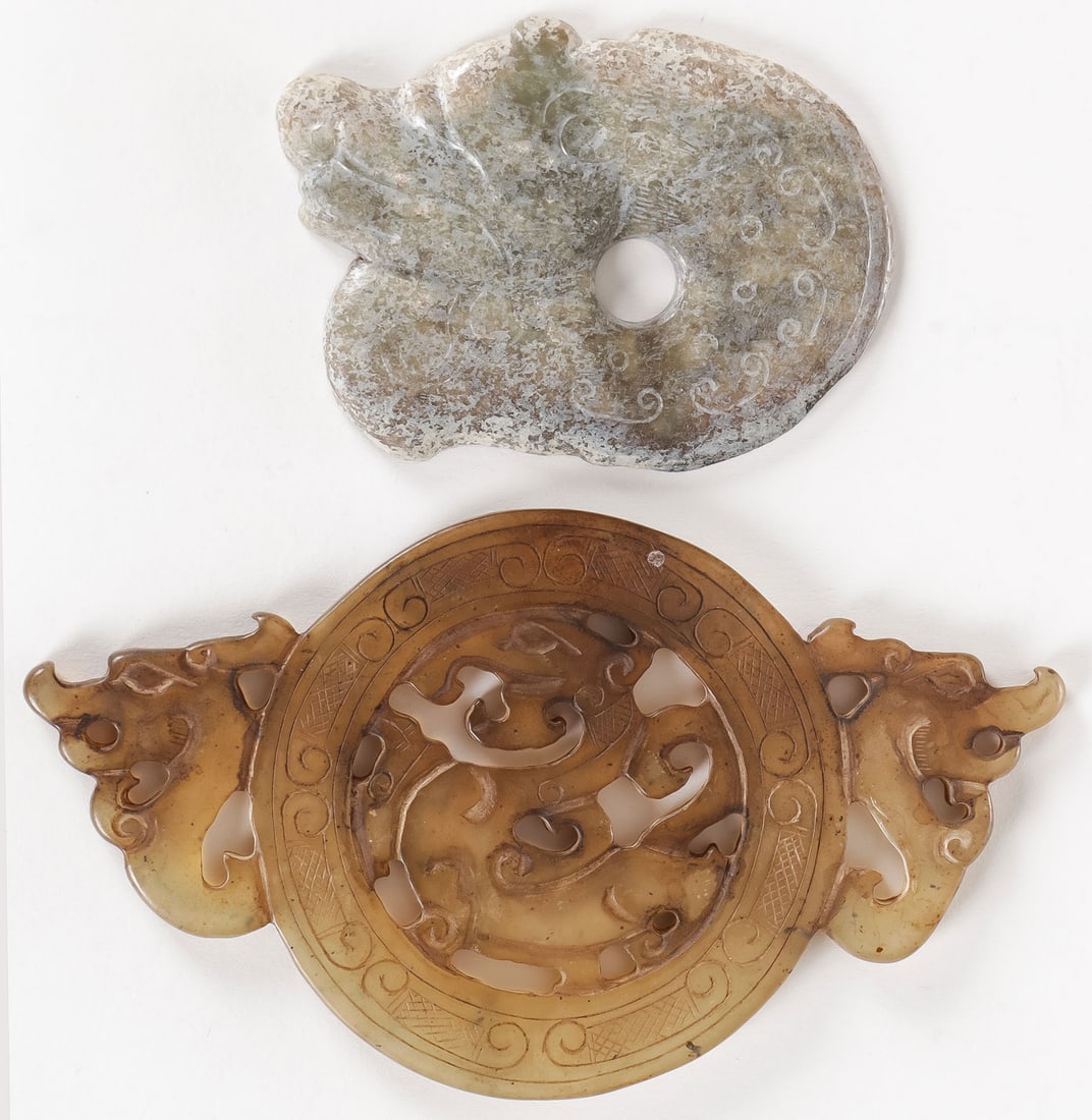 PAIR OF CHINESE JADE PENDANTS: PAIR OF CHINESE JADE PENDANTS. Below, a fine Han or Han-style pierced-carved jade pendant, the sides with dragon heads and at center also a dragon. Width 5.5 inches (14cm). And at top, a late Han coil