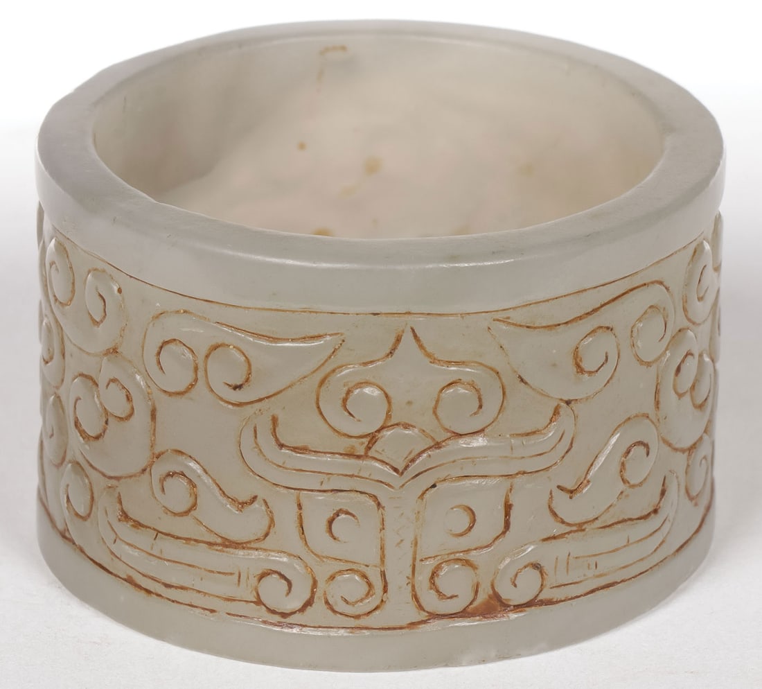 CHINESE CARVED JADE ARCHERS RING: CHINESE CARVED JADE ARCHERS RING. The sides banded with a carved repeating organic pattern. Diameter 1.9 inches (4.8cm), width 1.2 inches (3cm).SHIPPING NOTICE:If you are not using the Live Auctione