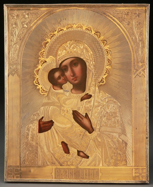 A RUSSIAN ICON OF THE VLADIMIR MOTHER OF GOD: A RUSSIAN ICON OF THE VLADIMIR MOTHER OF GOD. Naturalistically rendered and overlaid with an ornate silver-gilt machine engraved riza. Hallmarked Moscow, dated 1869, Cyrillic maker's mark PK and 84 si