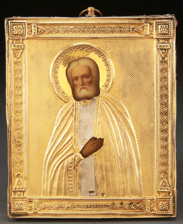 A RUSSIAN ICON OF ST. SERAPHIM OF SAROV, C 1910: A RUSSIAN ICON OF ST. SERAPHIM OF SAROV, CIRCA 1910. Naturalistically painted and overlaid with a finely crafted silver-gilt repoussé riza, hallmarked Moscow, circa 1908-1917, Cyrillic maker's mark S