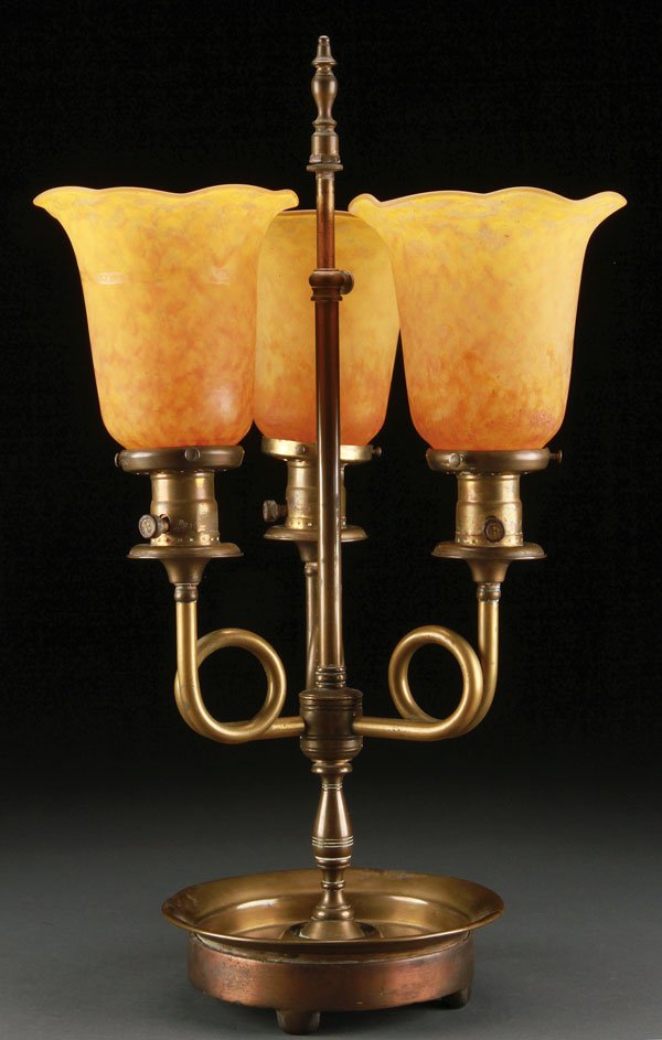 THREE DAUM NANCY FRENCH ART GLASS LAMP SHADES: A SET OF THREE DAUM NANCY FRENCH ART GLASS LAMP SHADES, EARLY 20TH CENTURY. Of lily form in grey glass, internally decorated with amber mottle, mounted on an associated brass three light candle form b
