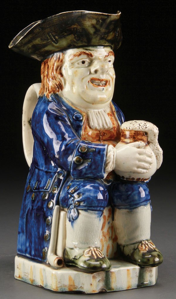 18TH CENTURY STAFFORDSHIRE CREAMWARE SEATED TOBY: AN 18TH CENTURY STAFFORDSHIRE CREAMWARE SEATED TOBY. Probably by Ralph Wood. In colored glazes including cobalt, brown and green. Height 10 inches (25.5 cm).