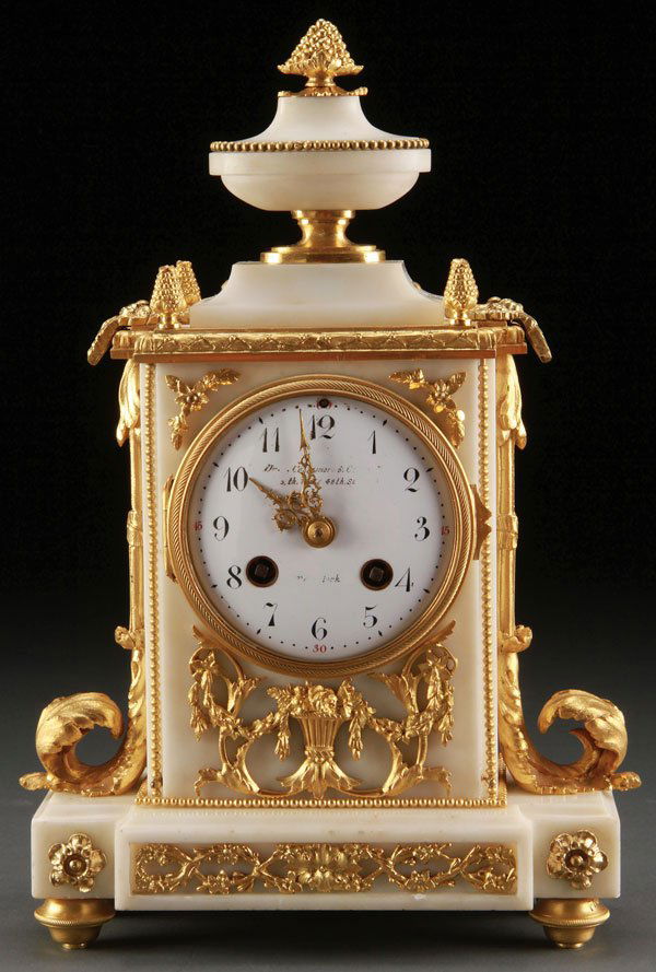 FRENCH GILT BRONZE MOUNTED ALABASTER TABLE CLOCK: A FRENCH LOUIS XVI STYLE GILT BRONZE MOUNTED ALABASTER TABLE CLOCK, CIRCA 1900. Retailed by Collamore and Company, New York. The rectangular alabaster case with scrolled acanthus and foliate mounts, s