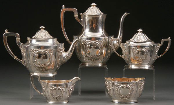 5 PC INTERNATIONAL STERLING SILVER TEA SET 58.2 TROY OZ: A FIVE PIECE INTERNATIONAL STERLING SILVER TEA SET, 20TH CENTURY. Chased and repousséd with wild roses and a scrolled cartouche engraved with an "L" monogram, comprising a coffee pot, tea pot, waste