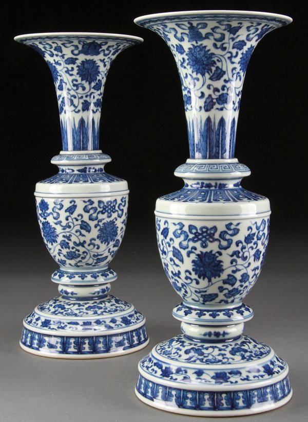 CHINESE BLUE & WHITE PORCELAIN ALTAR VASES, PAIR: A PAIR OF CHINESE BLUE AND WHITE PORCELAIN ALTAR VASES. Decorated with interlocking flowers and Buddhist symbols below a flaring rim. The base bearing Qianglong Archaic form line mark. Height 12.25 in