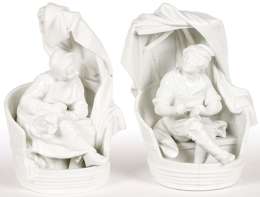 PR MEISSEN PORCELAIN FIGURES: PR MEISSEN PORCELAIN FIGURES. Comprising a complementary pair of Meissen porcelain figures depicting a stocking mender and a cobbler, each sitting in a barrel chair draped with a blanket. The undersid