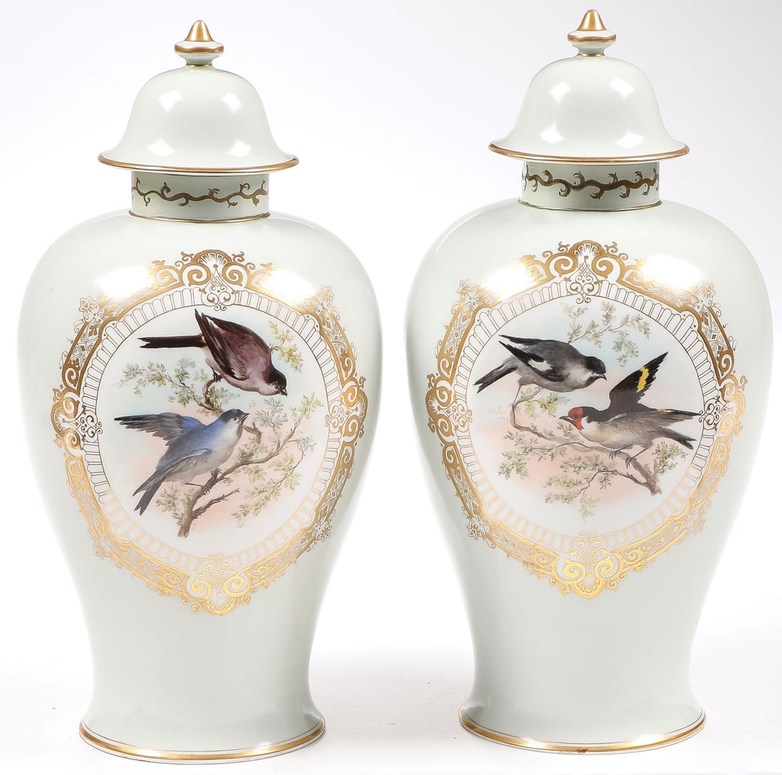 KPM LIDDED URNS: KPM LIDDED URNS. Comprising a pair of matching KPM lidded urns, the fronts decorated with finely hand-painted songbirds within a gilt reserve, and with fitted lids as shown, the underside of each