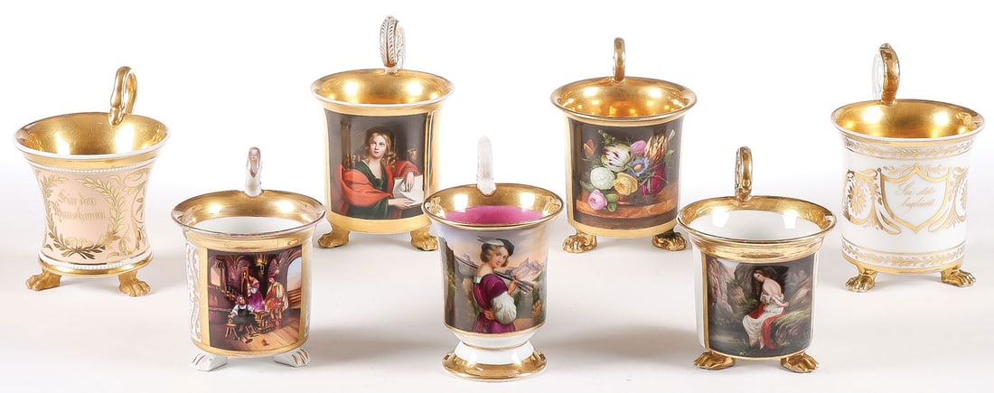 KPM & OTHER PORCELAIN CUPS, C. 1850: KPM & OTHER PORCELAIN CUPS, C. 1850. Comprising a good group of seven finely painted and gilt-decorated handled cups, including four examples with KPM scepter mark, one finely painted with the Evangel