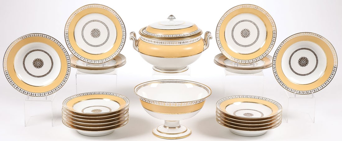 21 PCS SÈVRES PORCELAIN: 21 PCS SÈVRES PORCELAIN. Comprising 21 pieces of elegant Sèvres porcelain decorated with gilt accents, laurel wreaths, holly and ivy borders, and mustard-colored bands. Including 1 footed pu