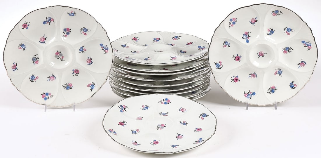 SET OF 12 LIMOGES OYSTER DISHES: SET OF 12 LIMOGES OYSTER DISHES. Comprising a set of 12 matching Charles Ahrenfeldt Limoges porcelain oyster plates, with silvered scalloped rim and overall decorated with flowers in the Art Deco tast