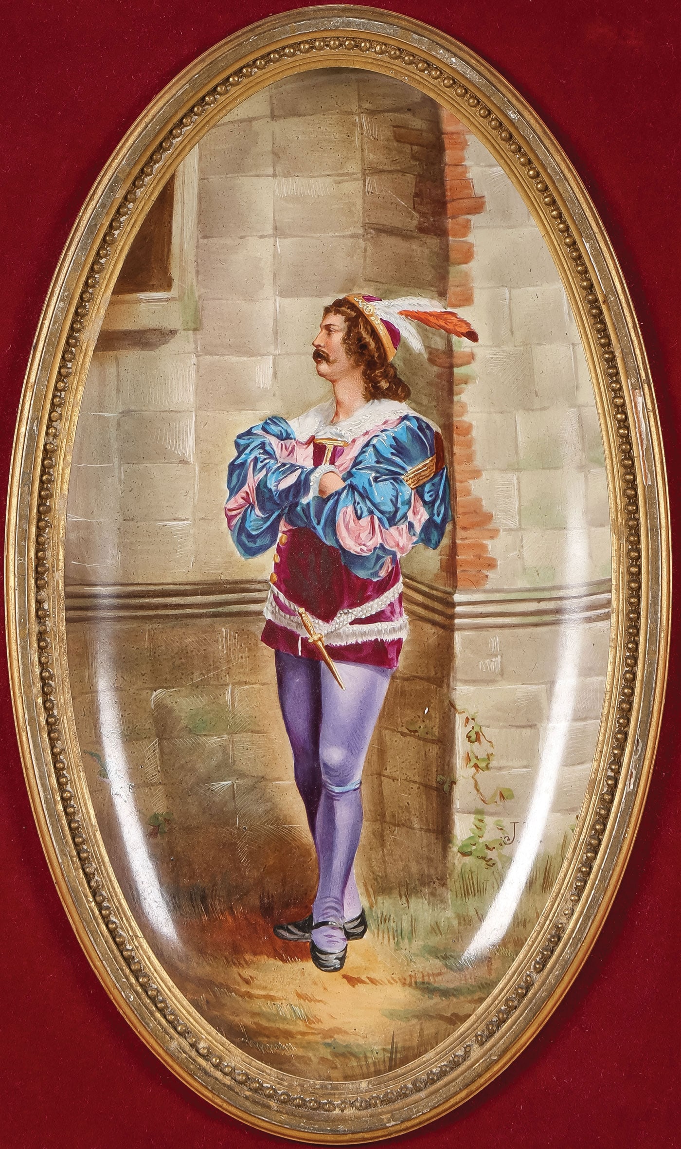 HAND PAINTED FRENCH PLAQUE: HAND PAINTED FRENCH PLAQUE. Comprising an oval concave plaque with finely painted figure of a nobleman in medieval attire with feathered hat and dagger. Artist initialed lower right J.B. within a