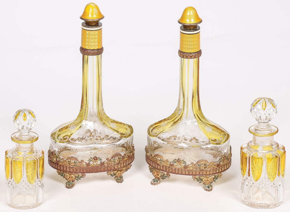CUT GLASS PERFUMES: CUT GLASS PERFUMES. Comprising a matching pair of Austrian amber flashed and etched glass bottle form perfumes, the collar and bell-shaped stopper in translucent amber enamel over a guilloche wavy gro