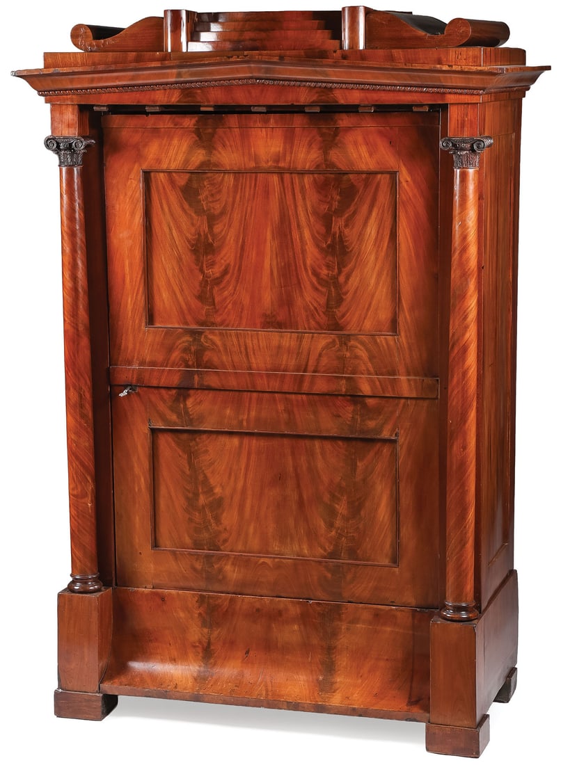 LOVELY PETITE BIEDERMEIER MAHOGANY WARDROBE: LOVELY PETITE BIEDERMEIER MAHOGANY WARDROBE. With side columns terminating with Corinthian capitals beneath a slightly arched cornice above a double-paneled single door and with shaped setback